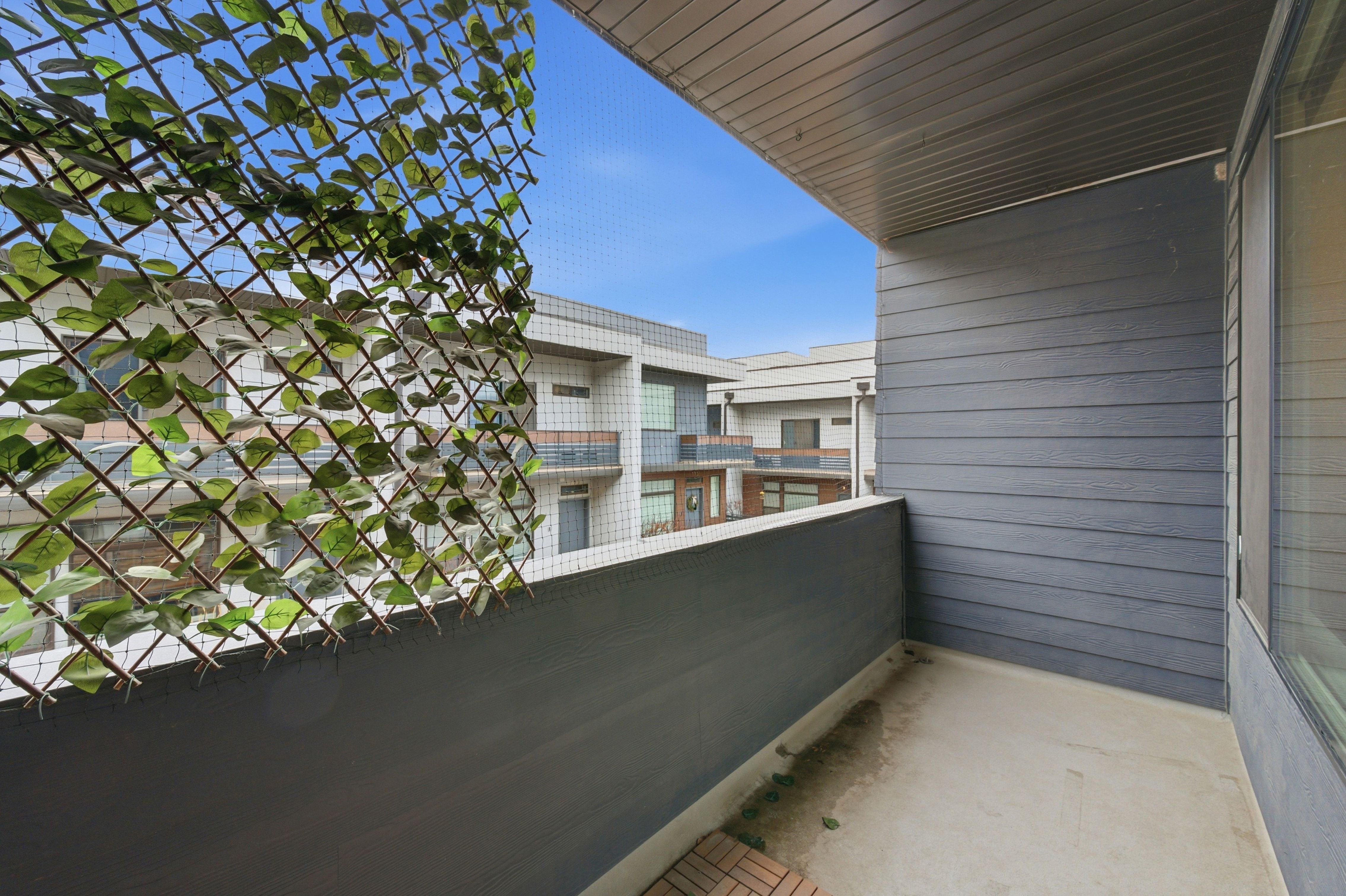 Private balcony featuring horizontal siding, a solid railing, and a slatted ceiling