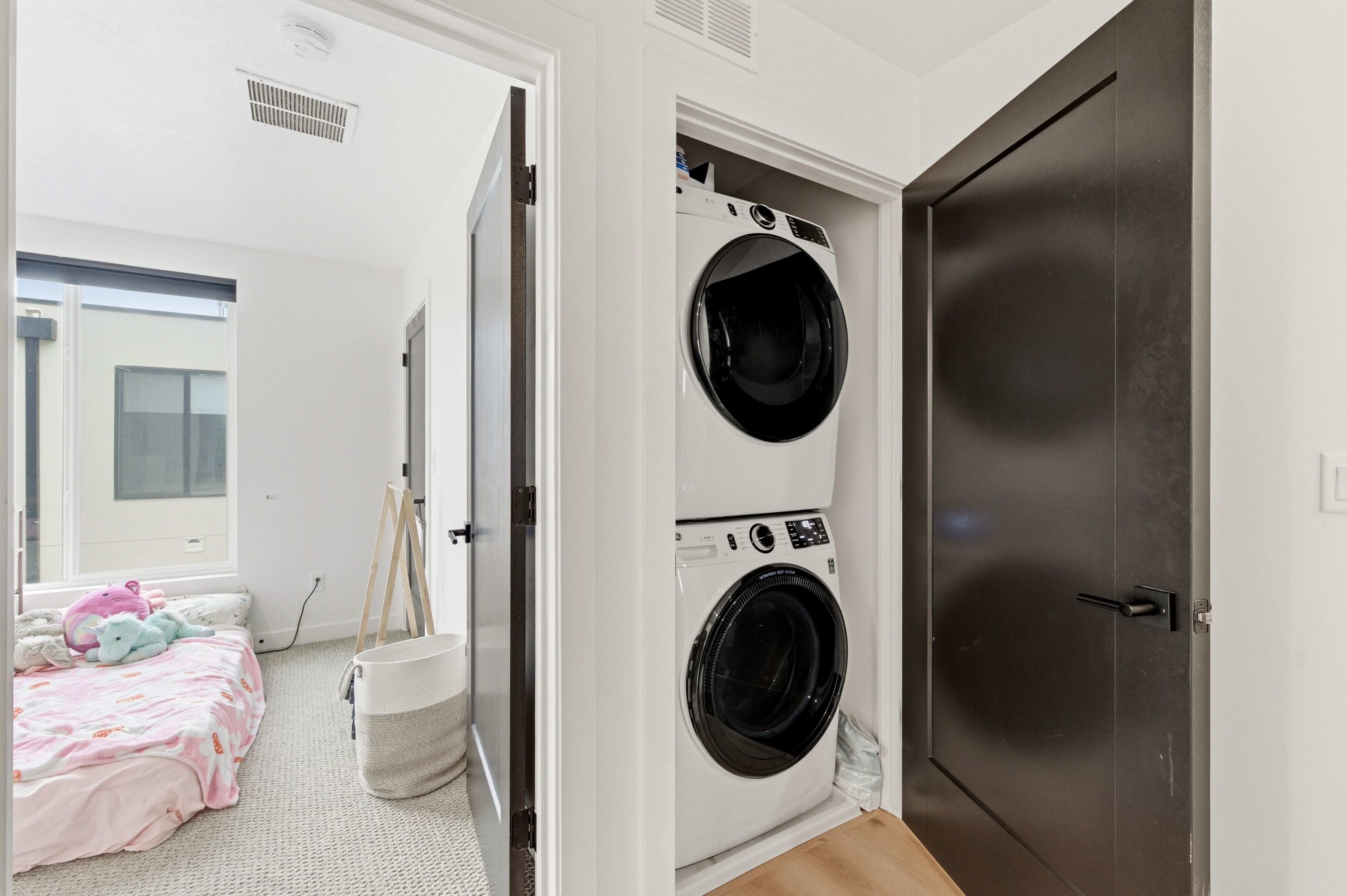 Stackable front-loading washer and dryer set within a dedicated alcove