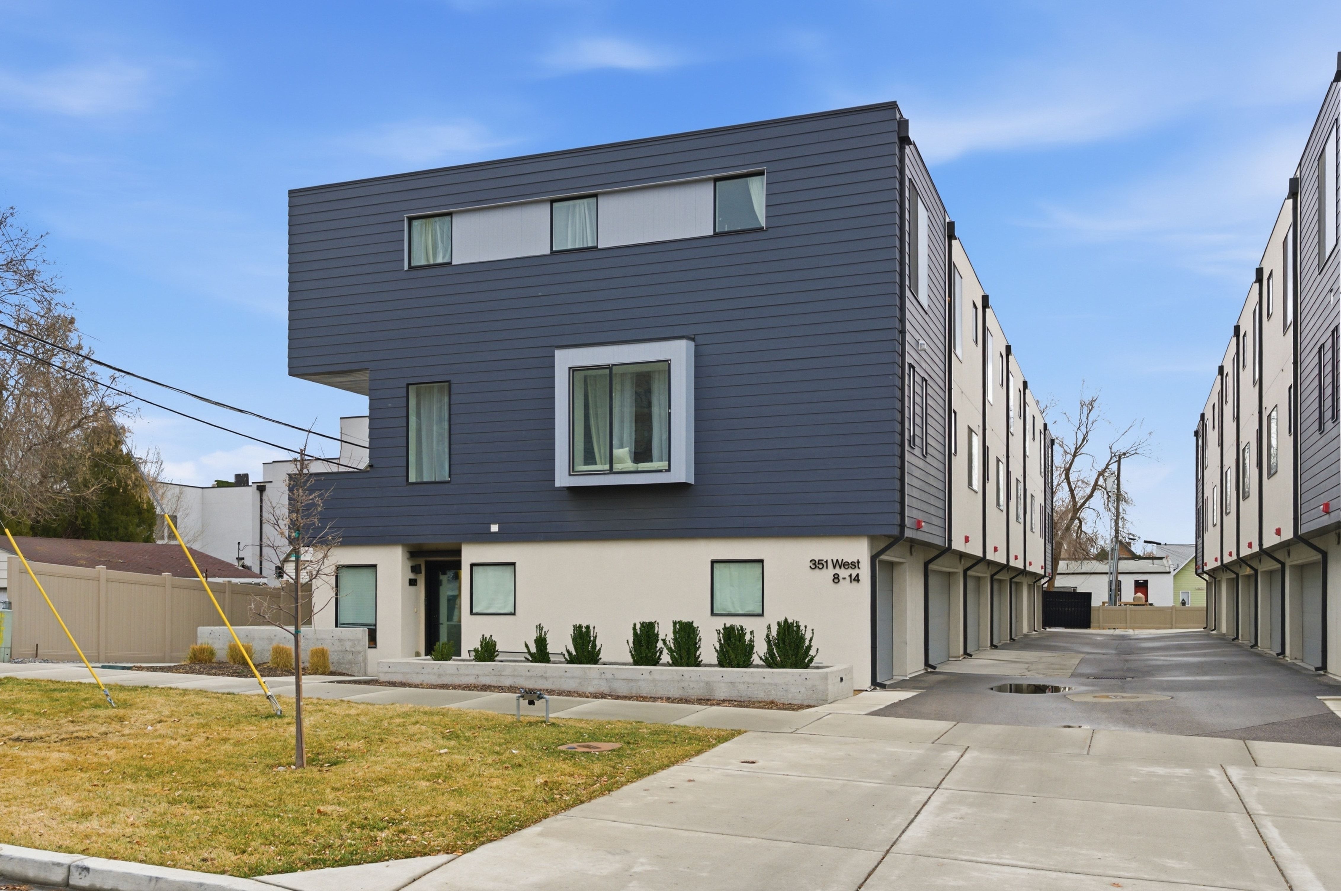 Modern architectural design featuring dark gray siding and light-colored stucco