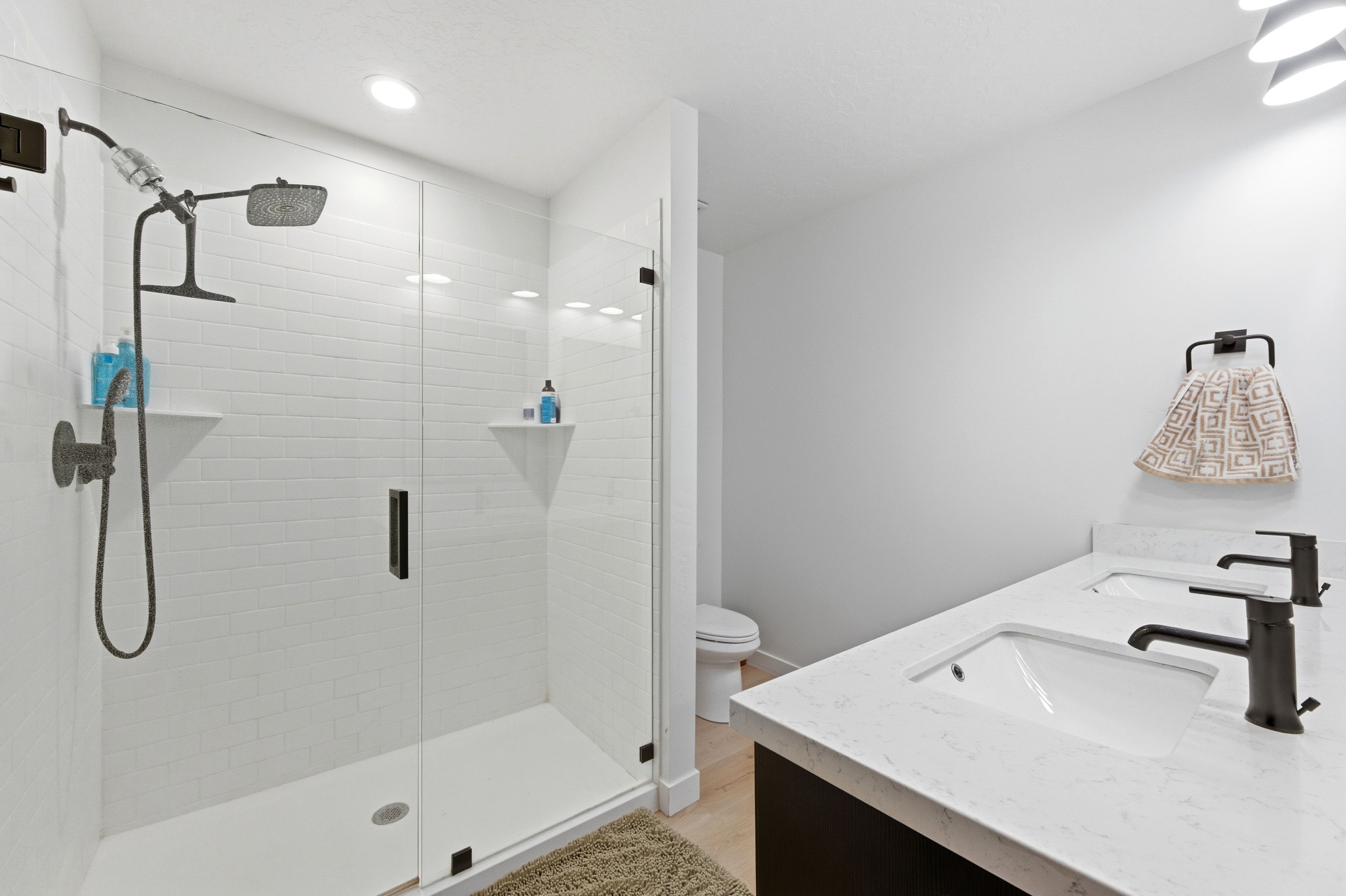 Modern bathroom featuring a double vanity with integrated sinks and black fixtures