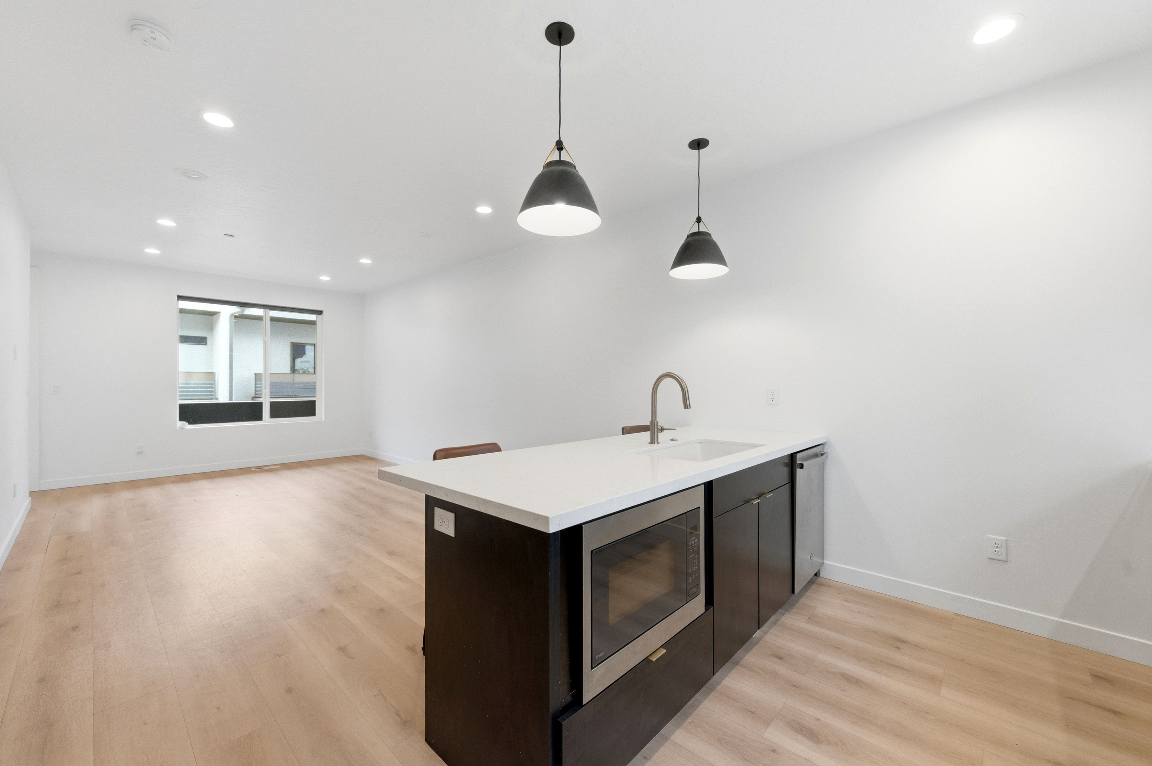 Kitchen island with white countertop, integrated sink, and stainless steel appliances
