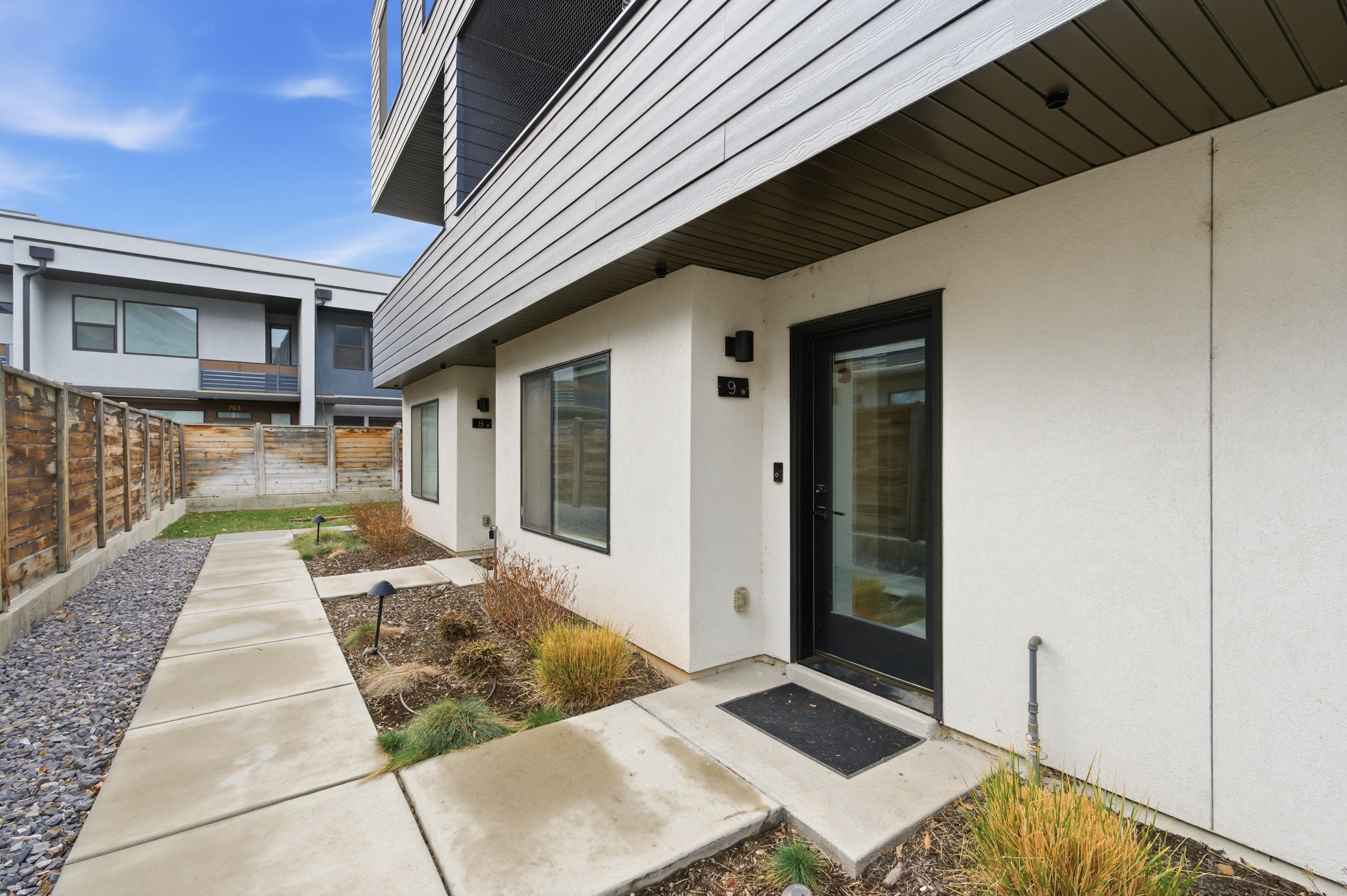 Modern exterior featuring white stucco and horizontal dark siding