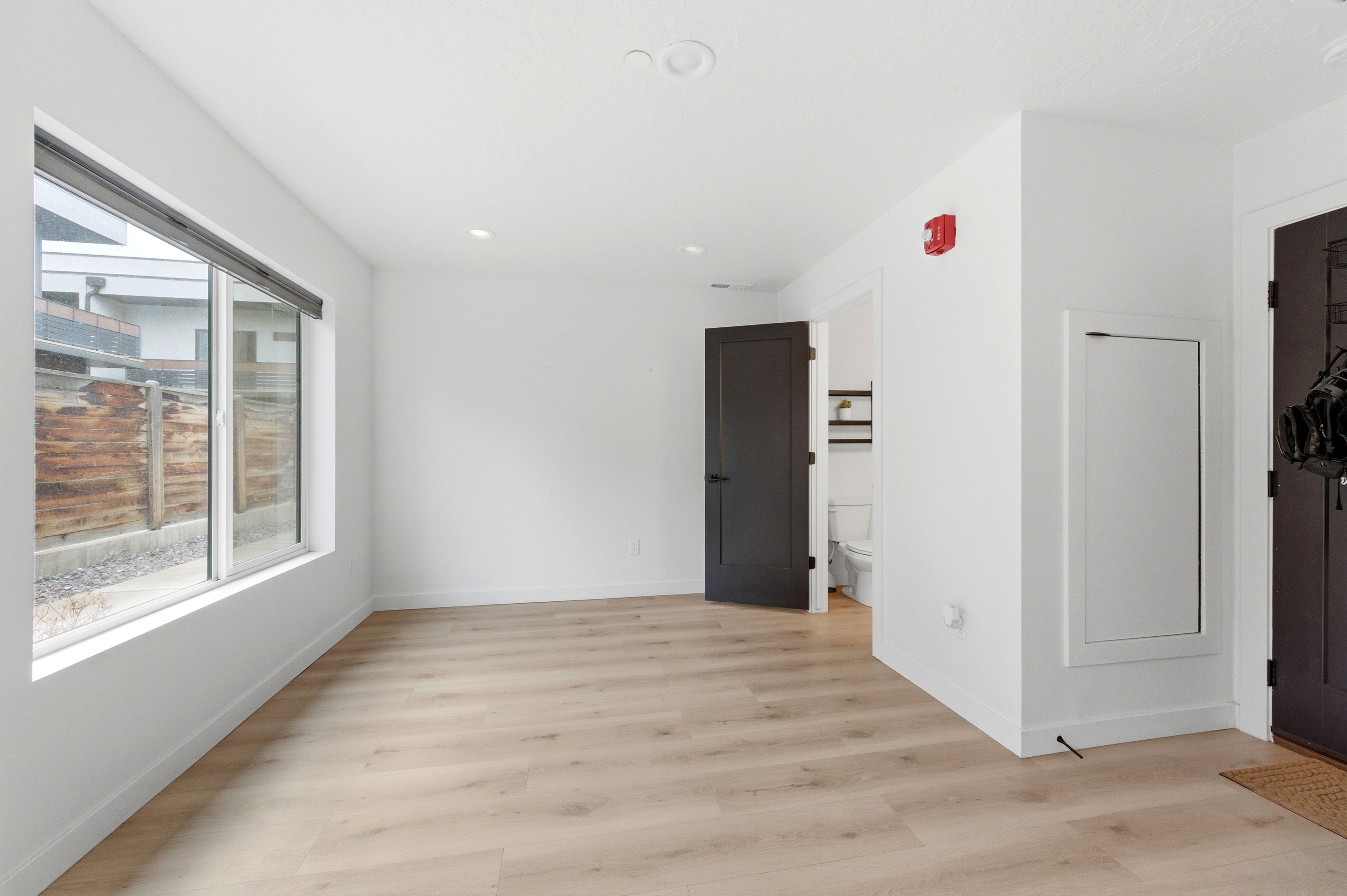 Bright interior space featuring light wood-finish flooring, recessed lighting, and a large window