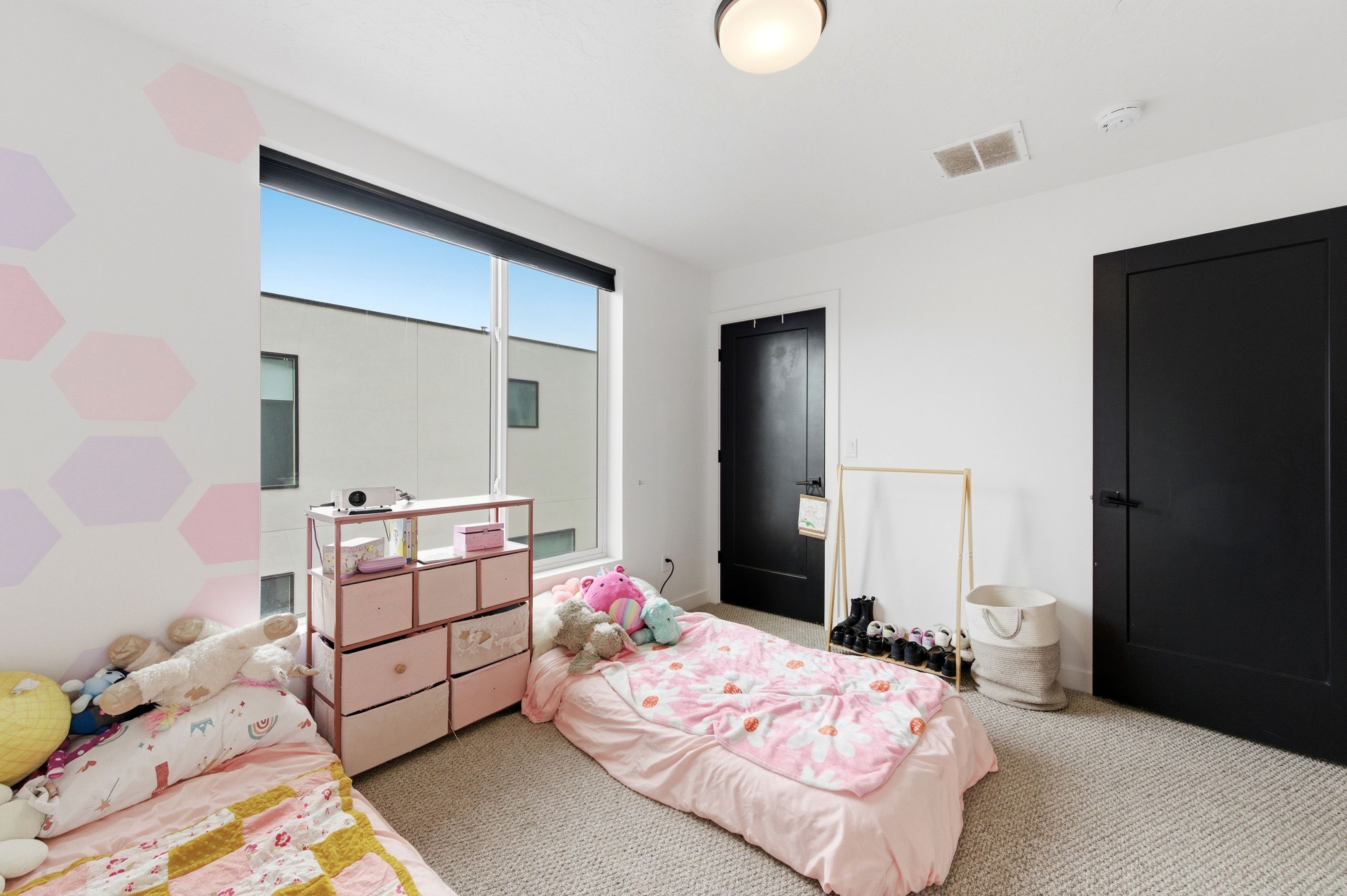 Room with large picture window, textured carpet, and two black interior doors