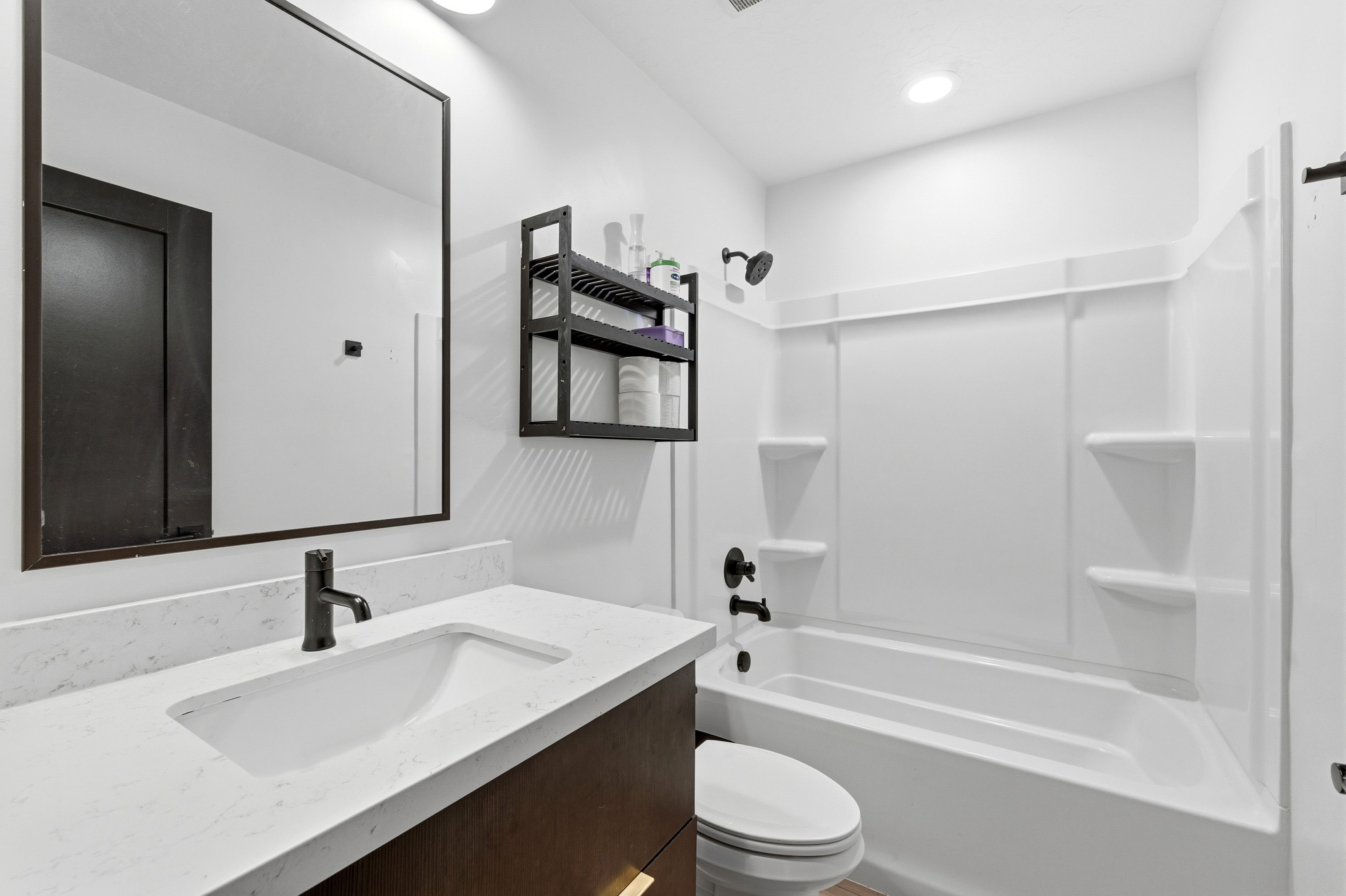 Bathroom featuring a dark wood-finish vanity with a light-toned countertop and integrated sink