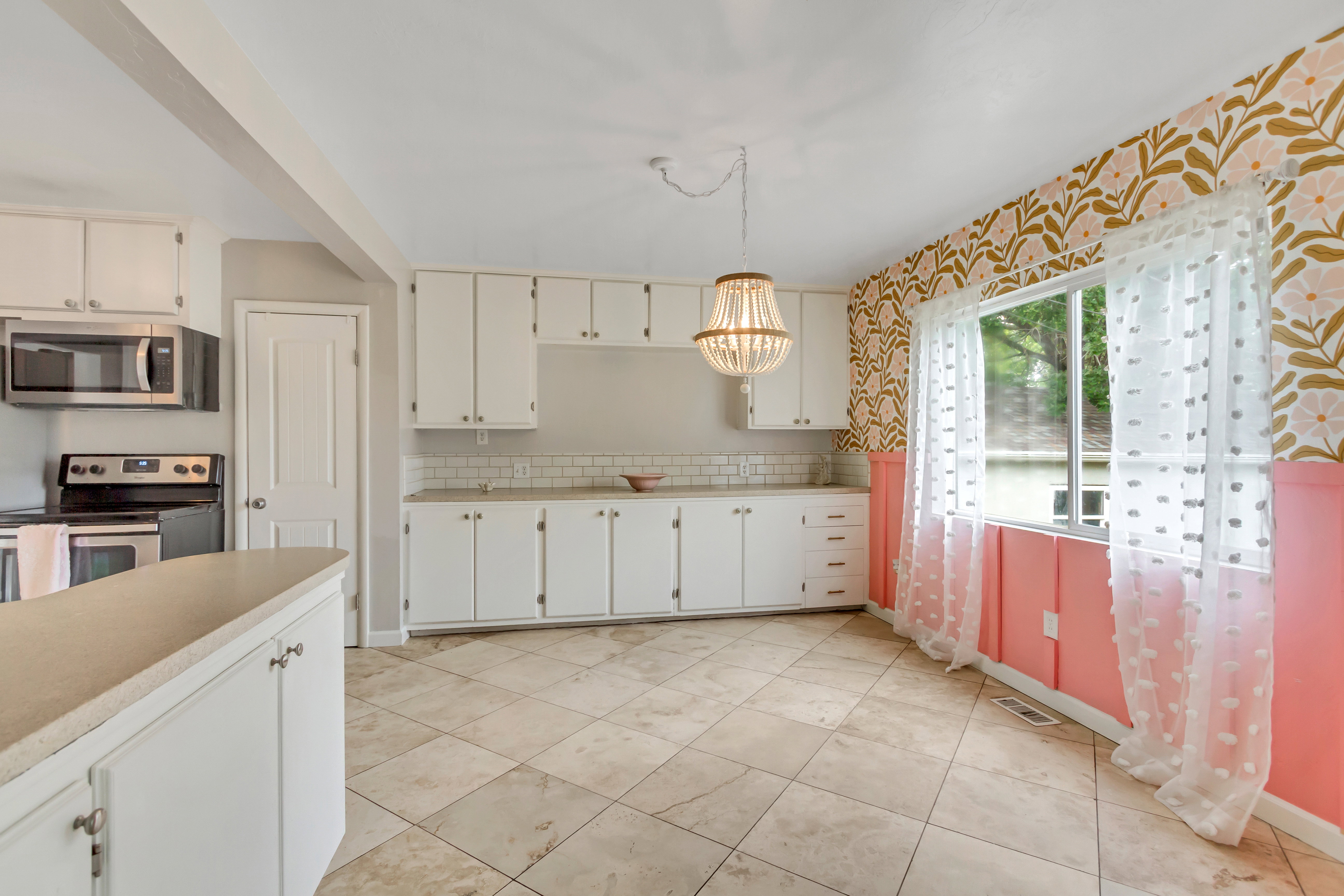 Kitchen featuring white cabinetry, subway tile backsplash, stainless steel appliances, and tile flooring