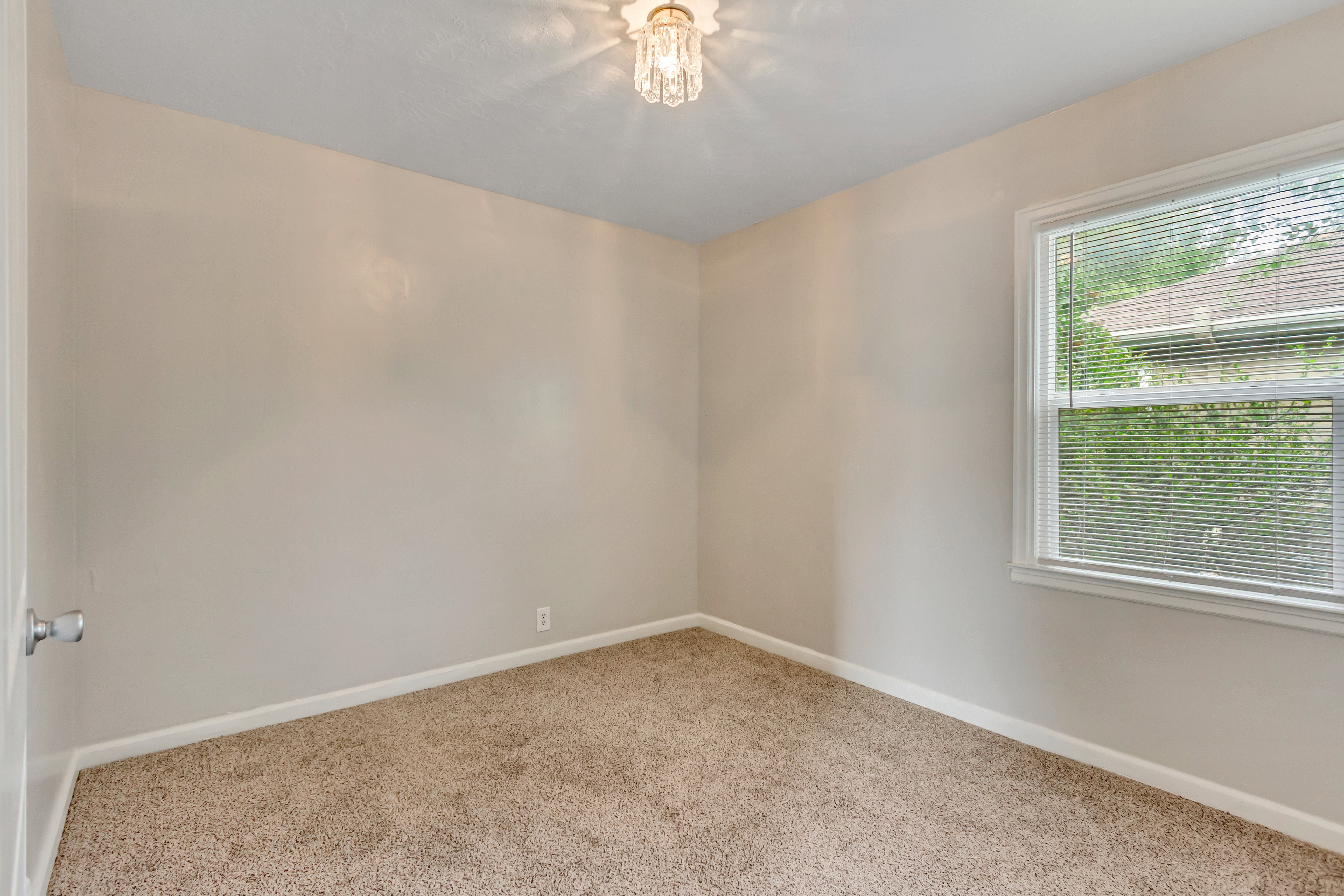Neutral-toned walls complement the textured carpet flooring