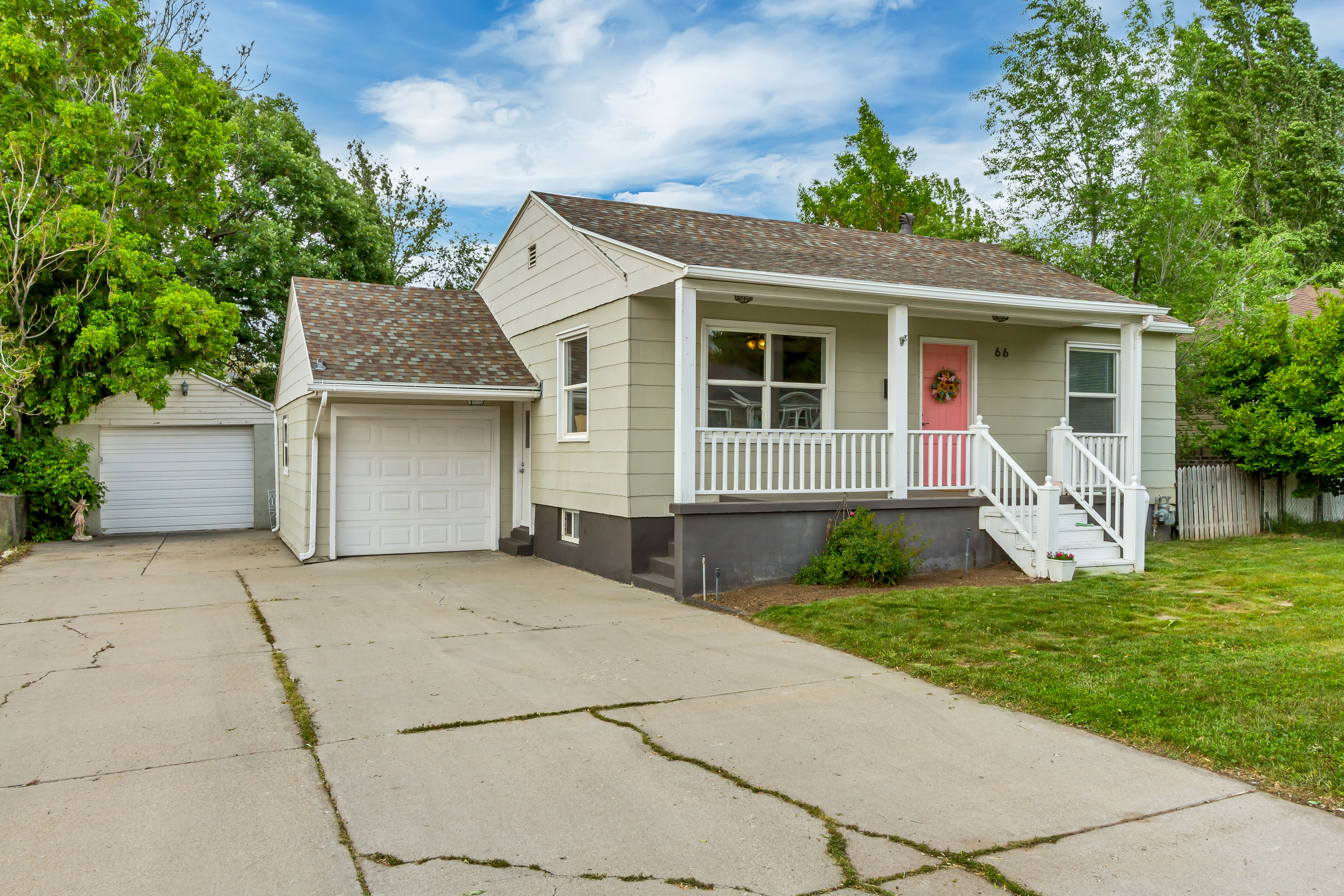 Light green siding exterior with a covered porch featuring white railings