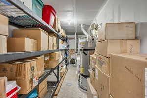 Dedicated utility area featuring a water heater, exhaust vent, and a single ceiling light fixture