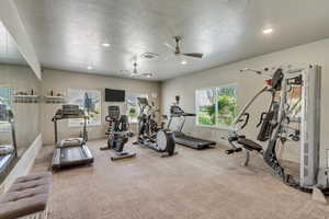 Dedicated fitness room featuring recessed lighting and two ceiling fans