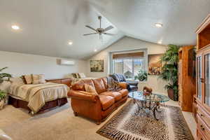 Spacious room with vaulted ceilings featuring recessed lighting, a ceiling fan, a split-system air conditioning unit, and plush carpeting