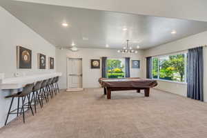 Spacious room featuring broad windows with exterior views, recessed lighting, and a modern chandelier