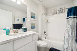 Bathroom featuring a white vanity with an integrated sink, brushed nickel faucet, and a quartz-finish countertop