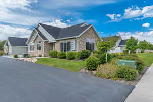 Stone and siding exterior with a dark shingle roof