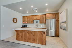 Kitchen area featuring wood-finish cabinetry and a white countertop