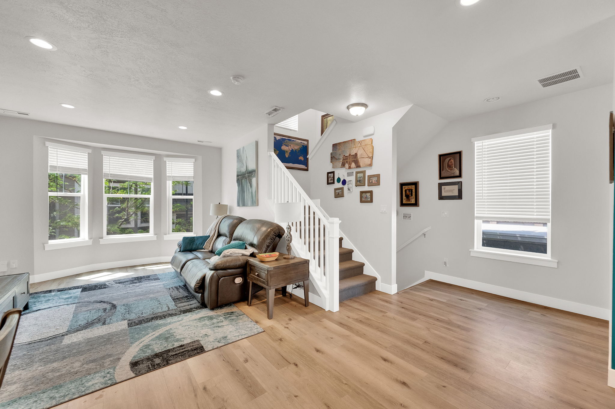 Living area with light-toned wood-finish flooring, white baseboards, and neutral wall paint