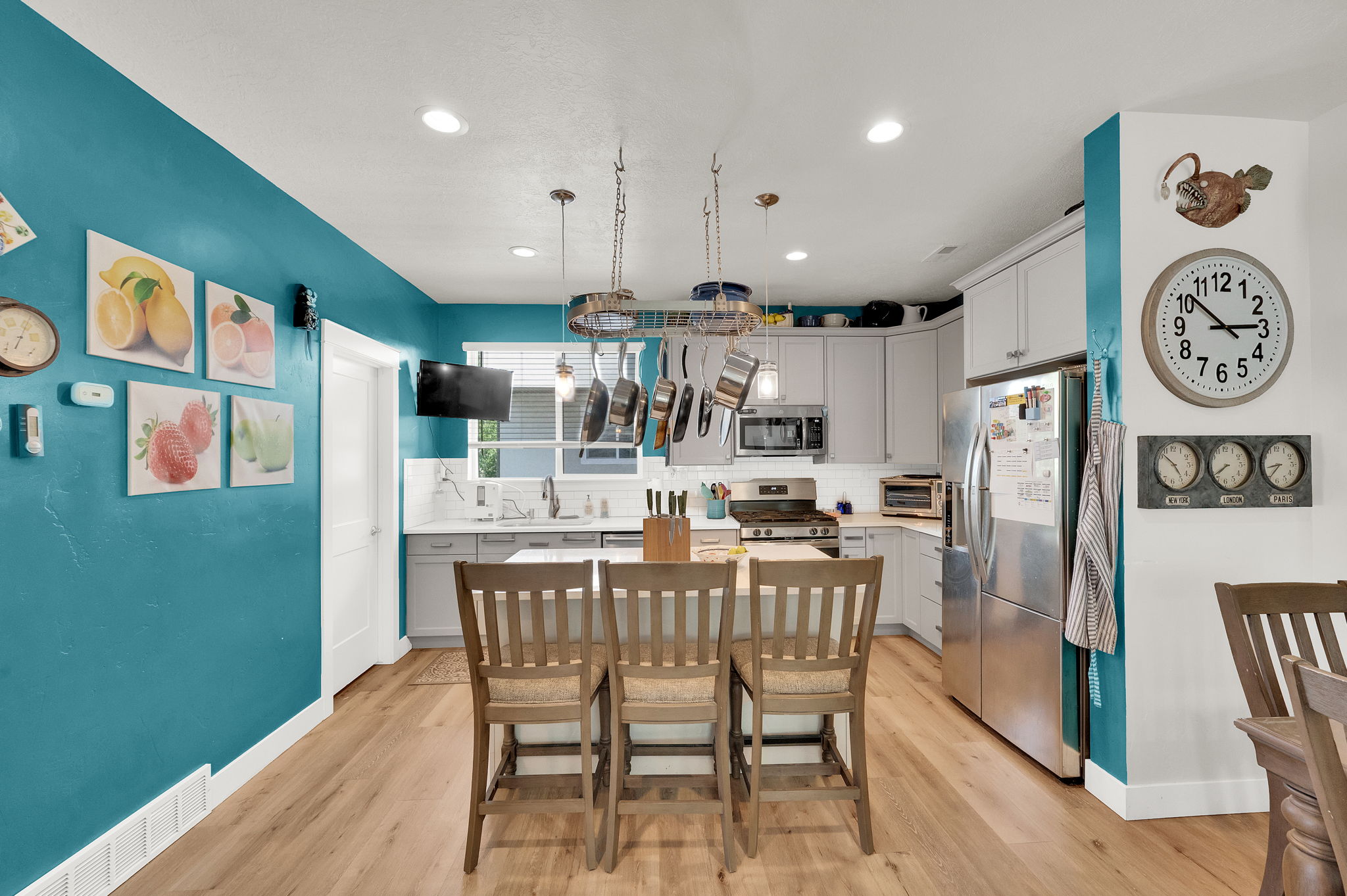 Kitchen featuring wood-finish flooring, white cabinetry, and stainless steel appliances