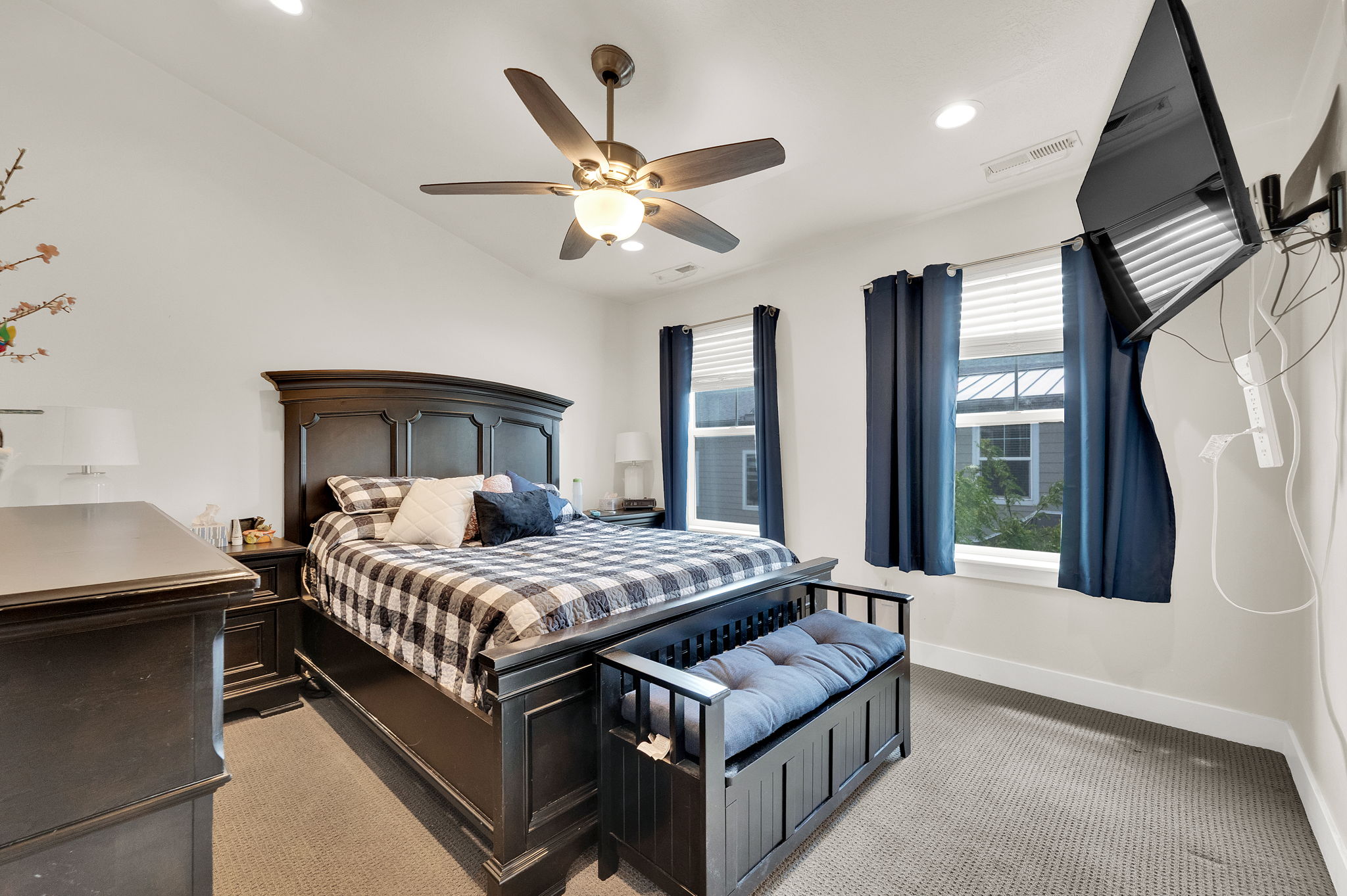 Vaulted ceiling bedroom featuring a ceiling fan with integrated lighting, recessed lighting, and two windows with blinds