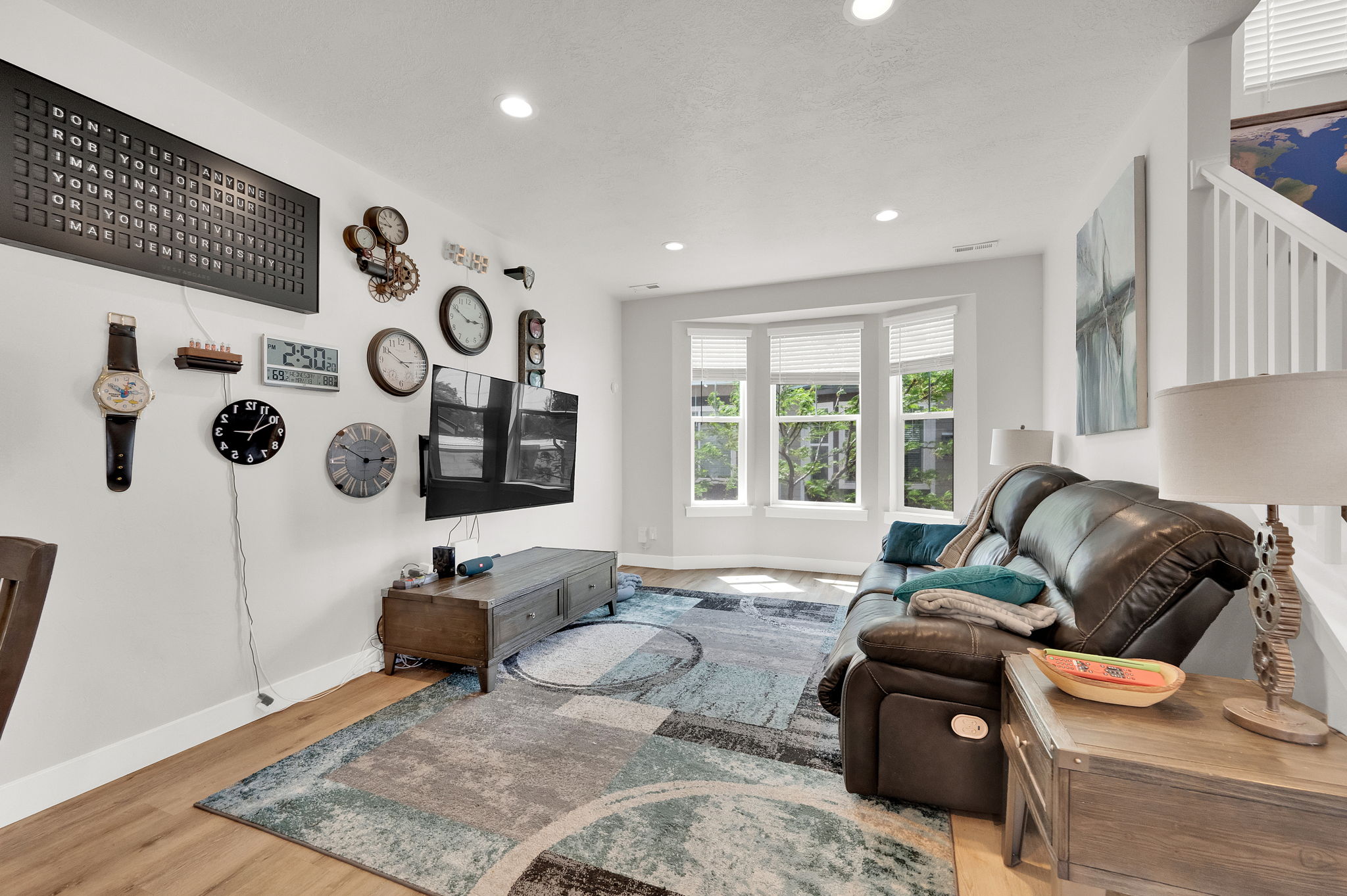 Light-filled living area featuring a bay window with white blinds, recessed lighting, wood-finish flooring, and white wall trim