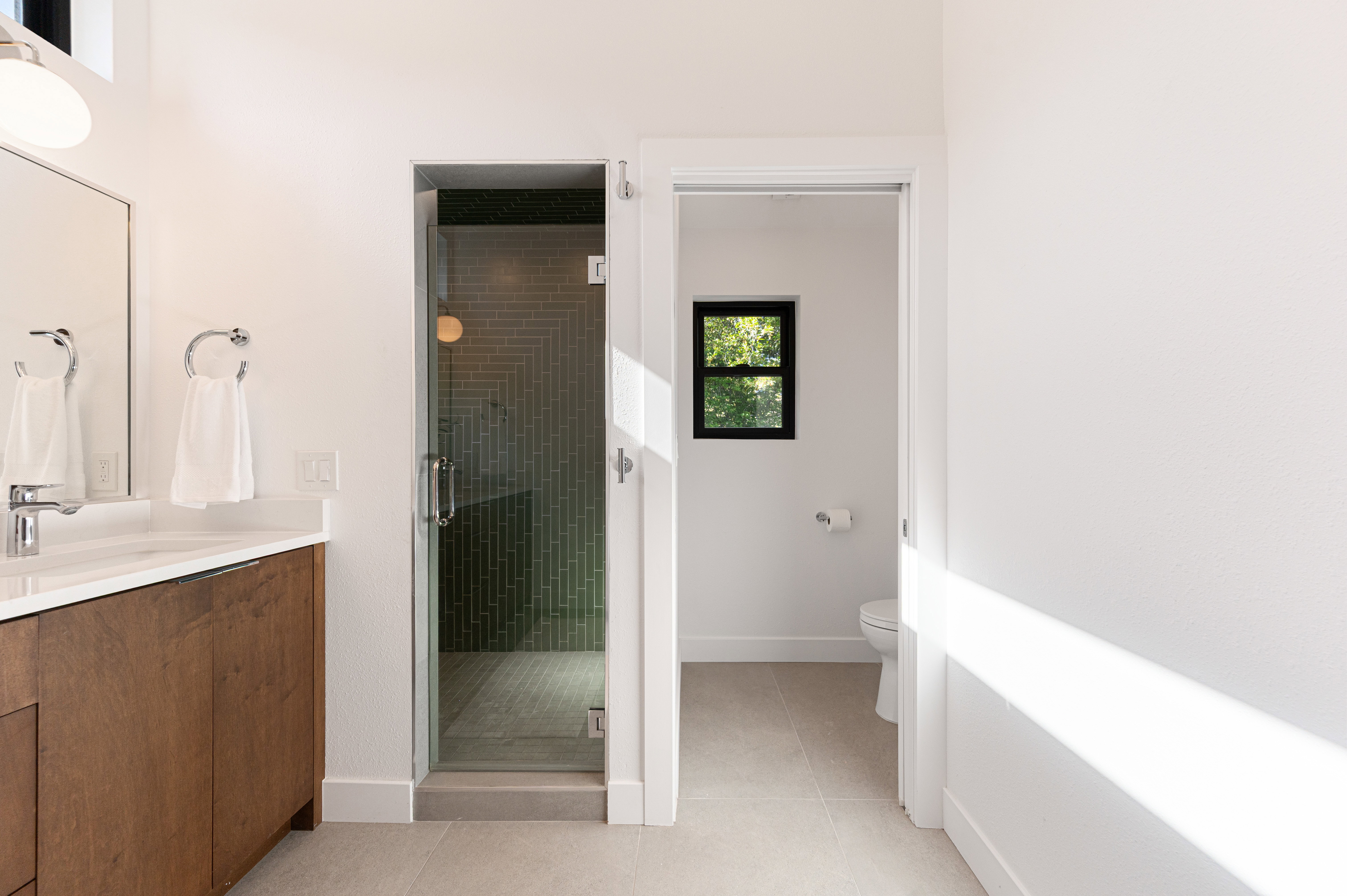 Modern bathroom featuring a wood-finish vanity with an integrated white sink and chrome faucet