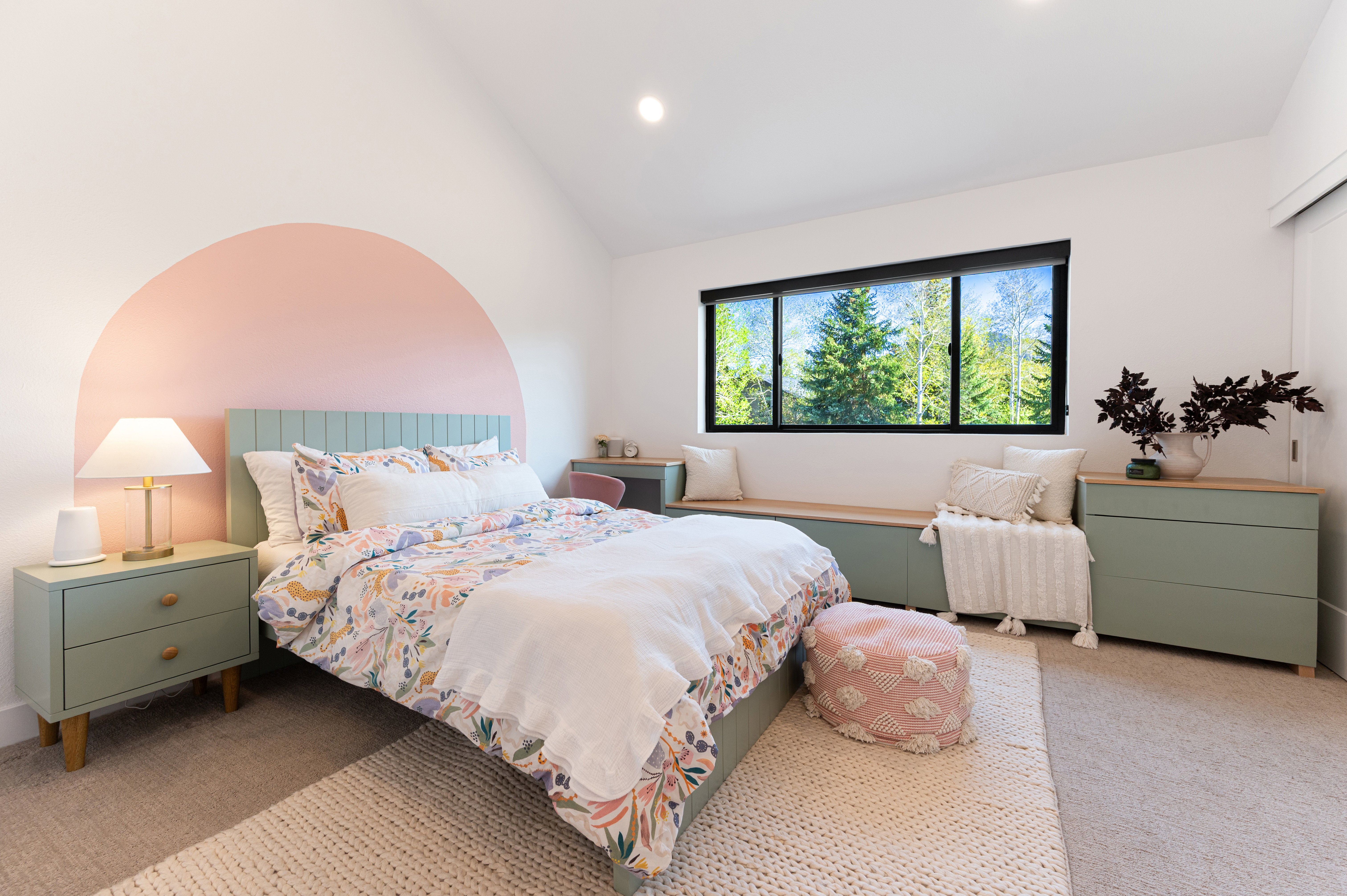 Bedroom featuring a large window, built-in window bench, light-colored carpeting, and a vaulted ceiling