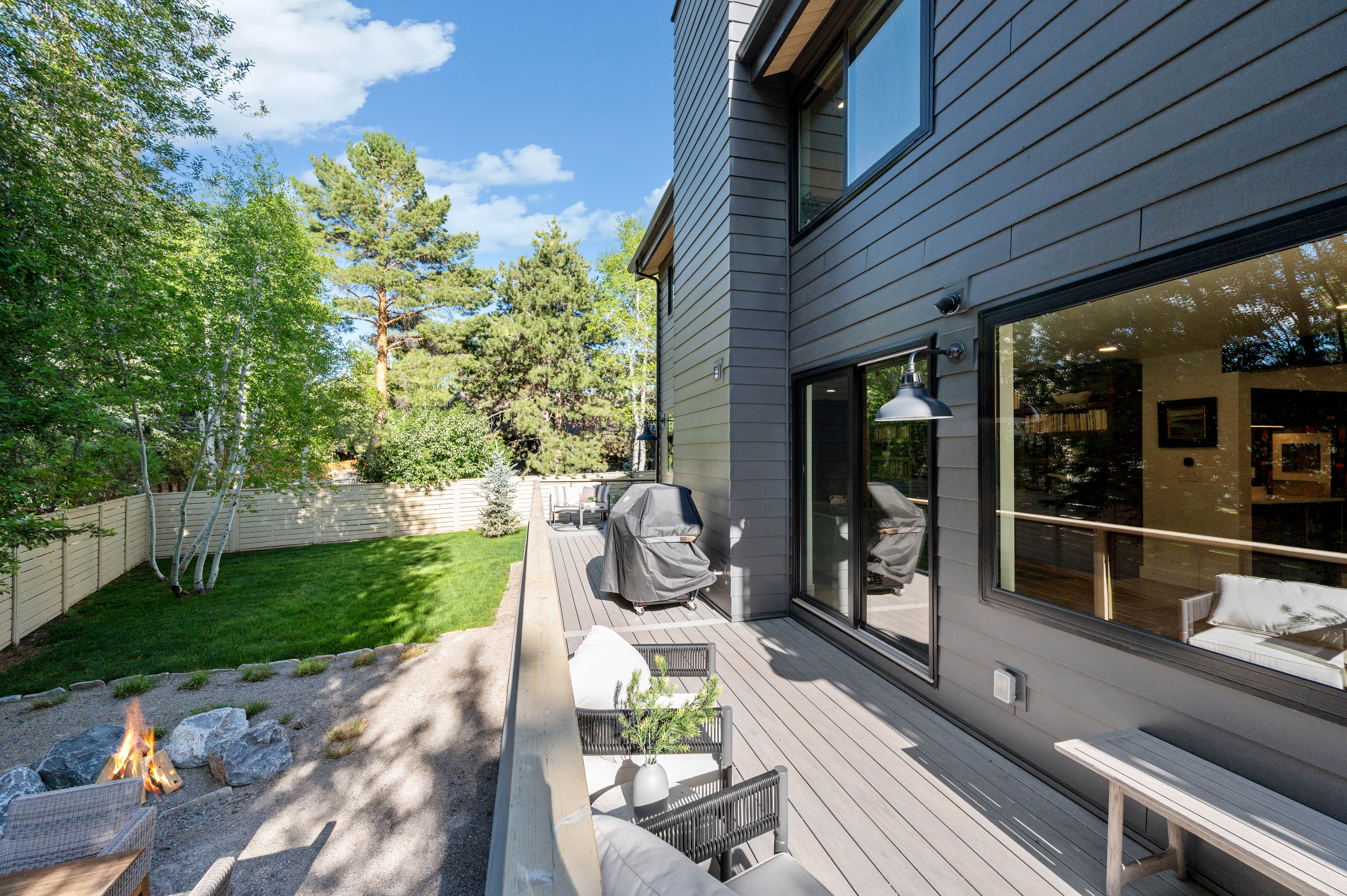 Contemporary exterior featuring dark siding, large windows, and a sliding glass door