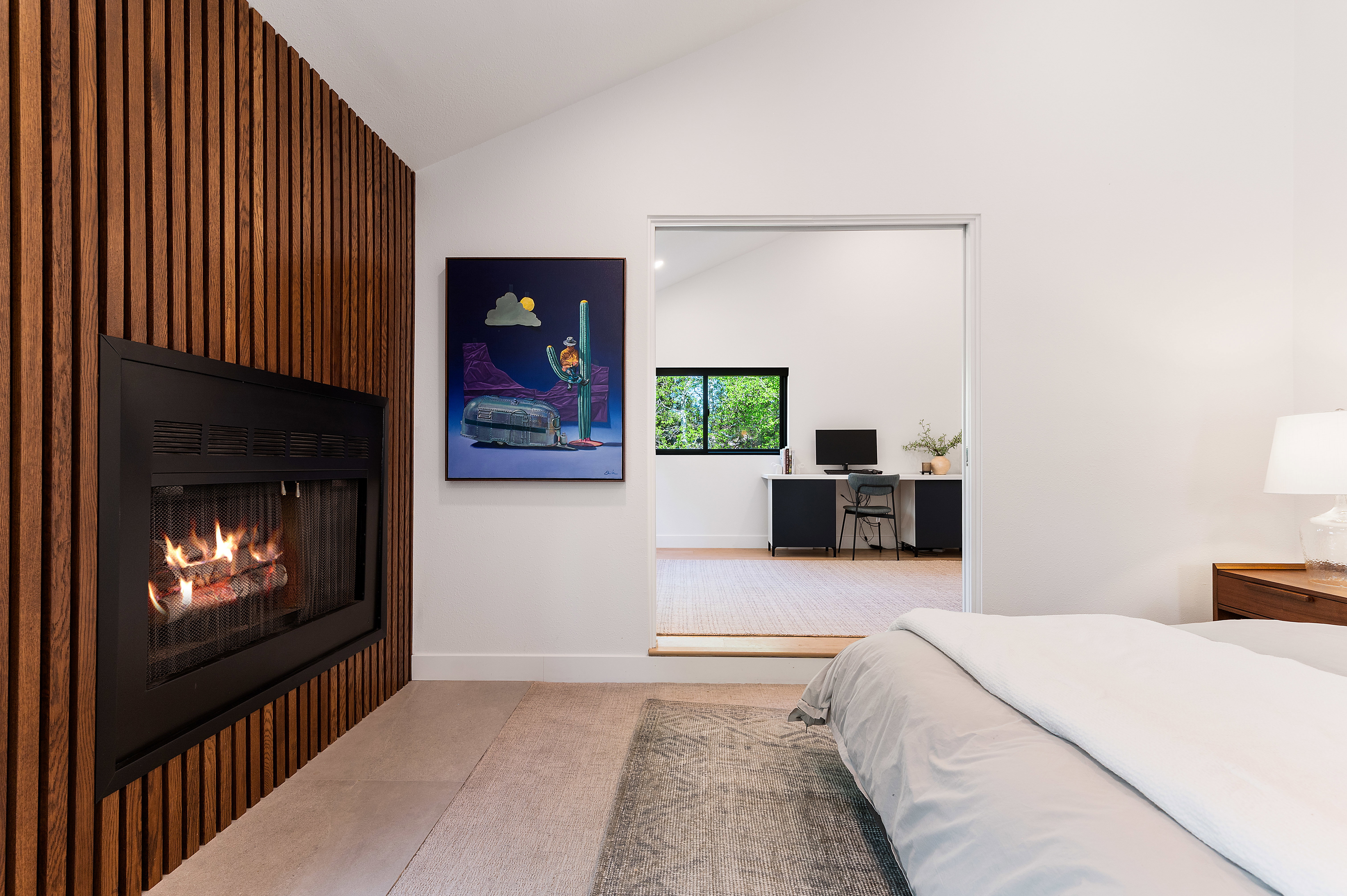 Modern fireplace with a wood-slat surround and a vaulted ceiling