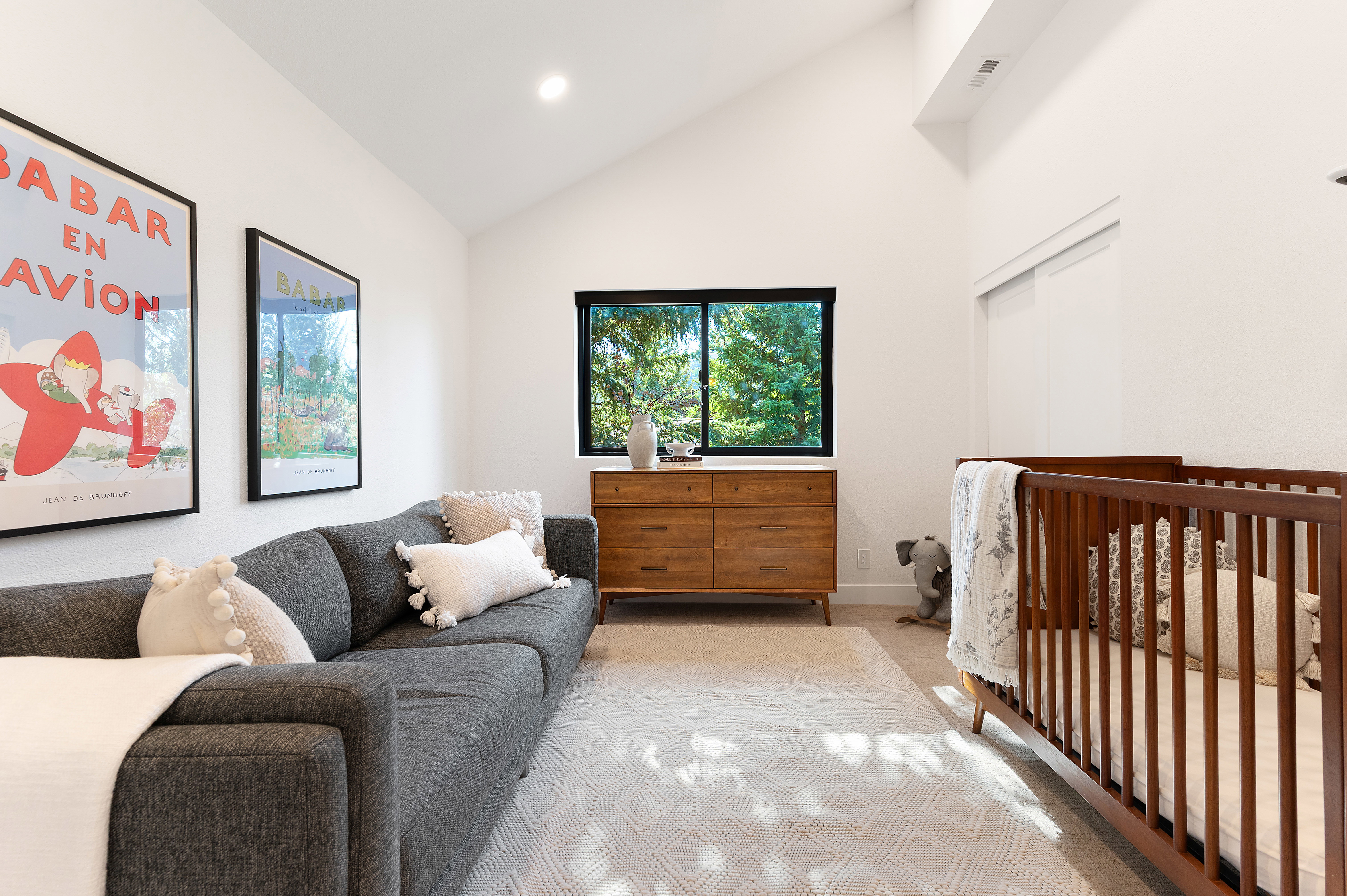 Vaulted ceilings enhance this bright room featuring recessed lighting, a built-in window with a dark frame, and a sliding closet door