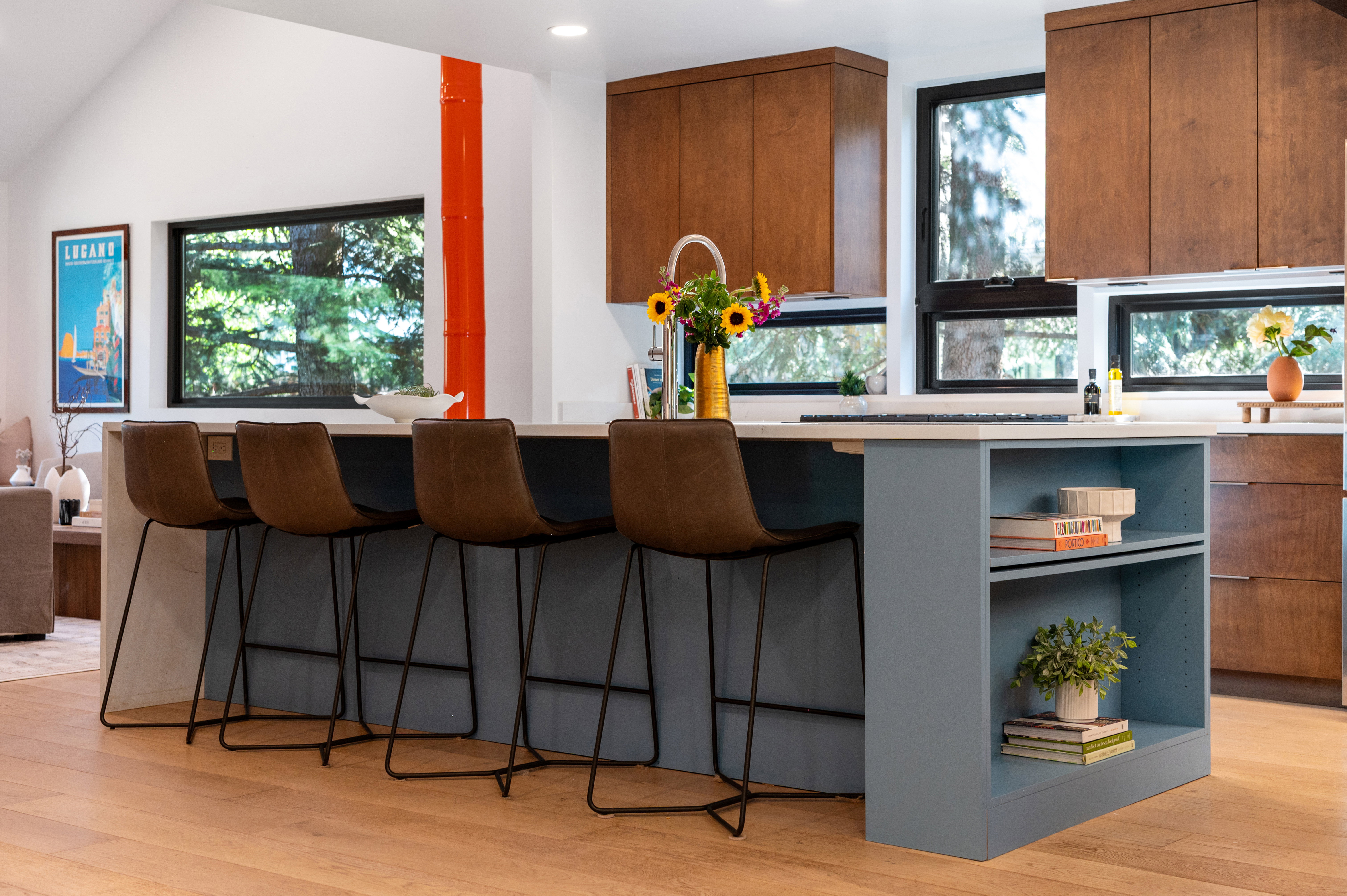 Kitchen island with light-toned countertop, integrated shelving, and a matte blue base