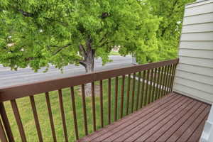 Private balcony featuring composite decking and a sturdy wood railing