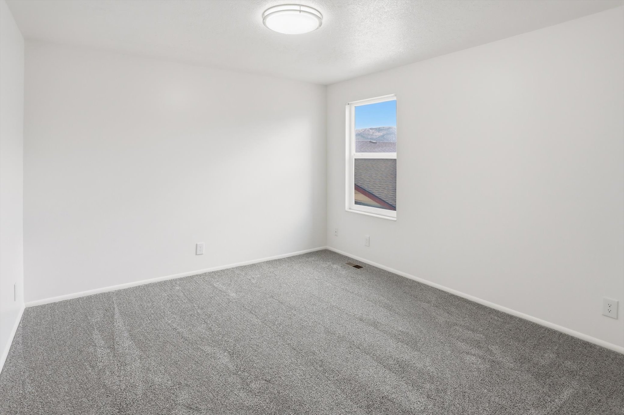 Neutral-toned wall-to-wall carpeting and bright white walls establish a versatile interior space