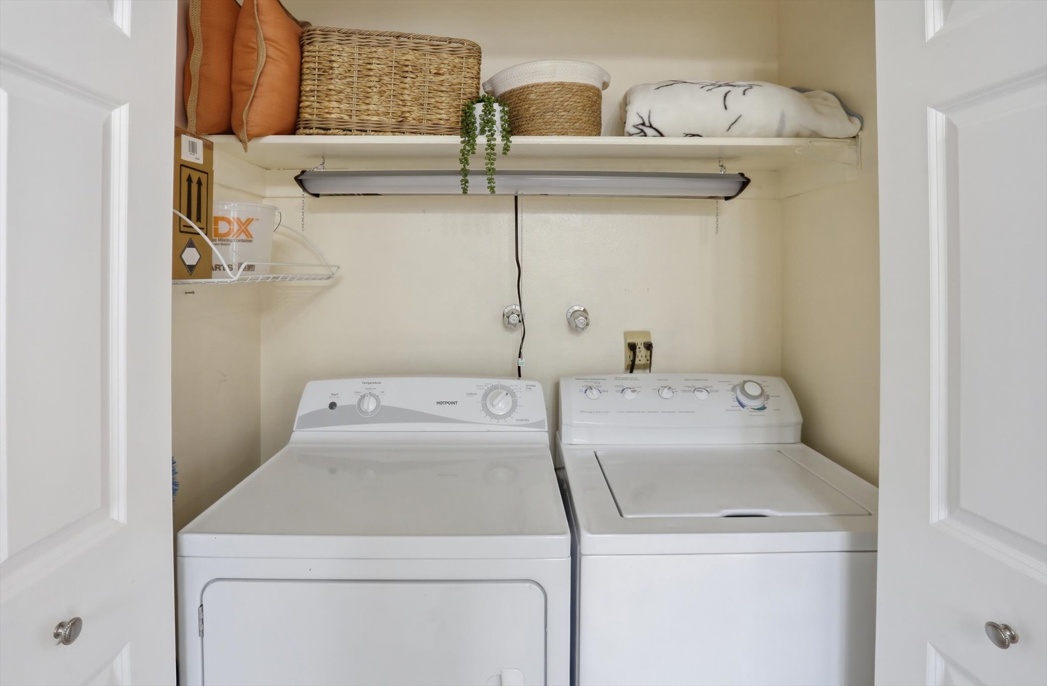 Dedicated laundry area featuring a white top-load washing machine and a white front-load dryer