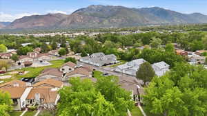 Neighborhood aerial featuring a mountainous backdrop, mature trees, and residential properties with various rooflines