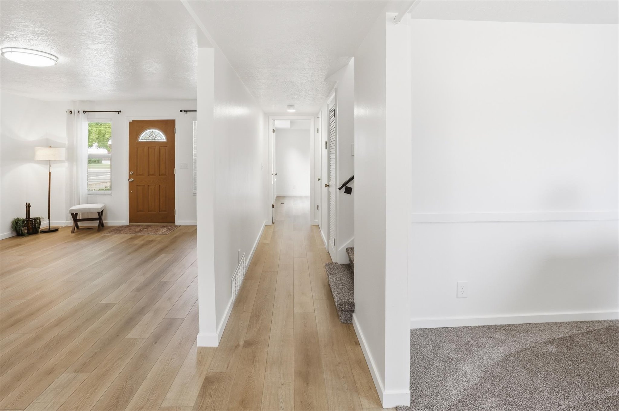 Light wood-finish flooring throughout, complemented by crisp white walls and white trim