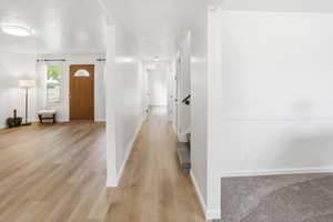Light wood-finish flooring throughout, complemented by crisp white walls and white trim