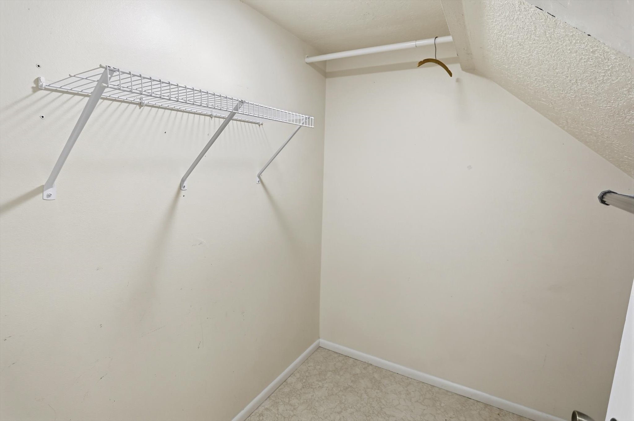 Walk-in closet with wire shelving and a hanging rod