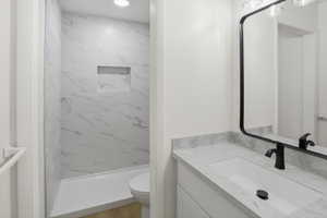 Bathroom featuring a vanity with an integrated sink, a dark-toned faucet, and a large framed mirror