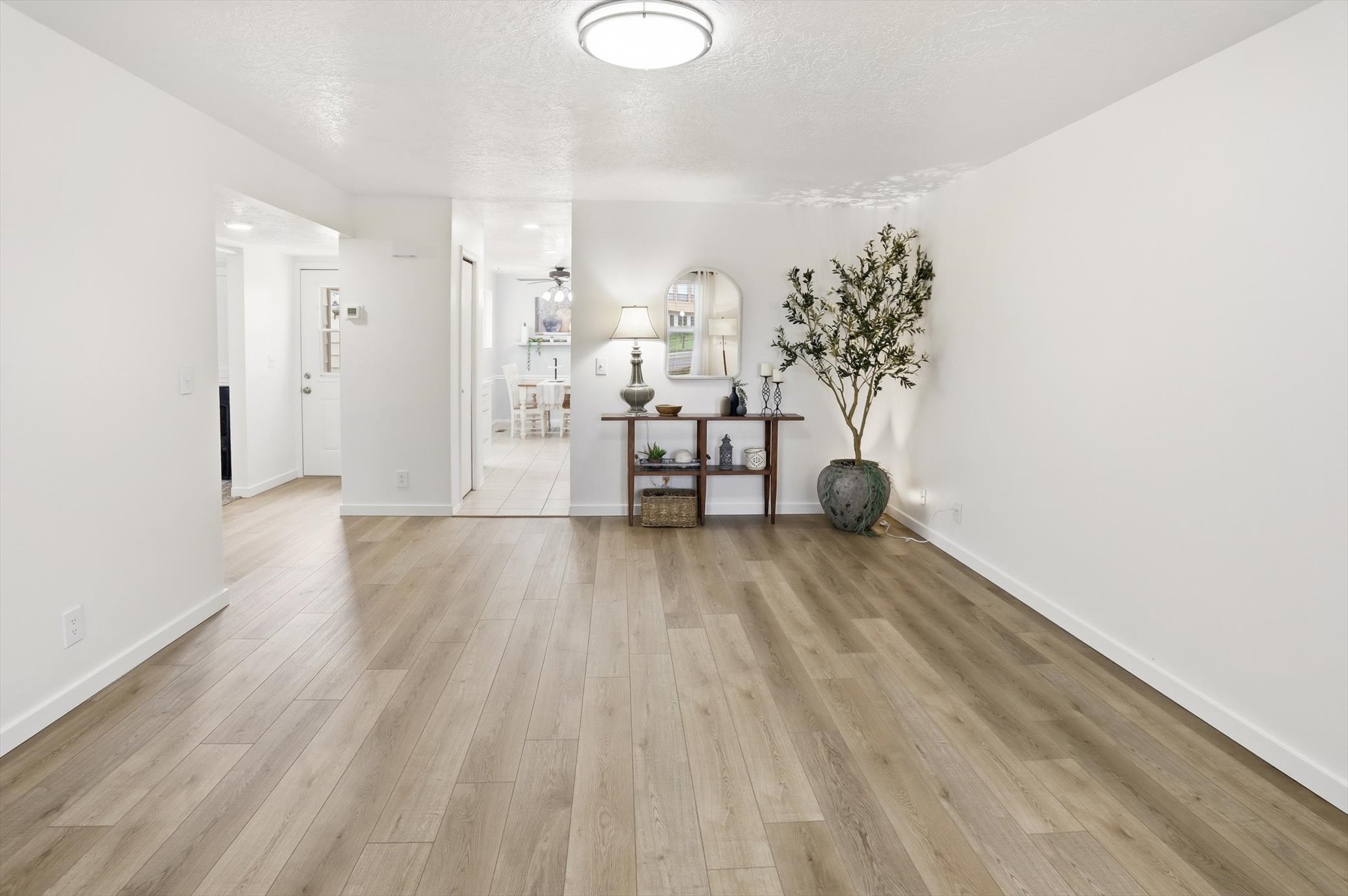 Spacious room featuring wood-finish flooring, white baseboards, and neutral wall paint