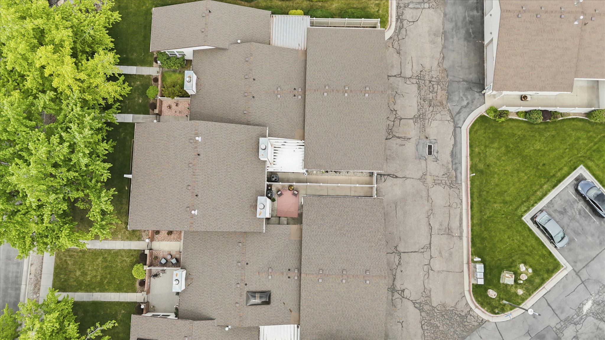 Brown shingle roofing with visible air conditioning units and skylights