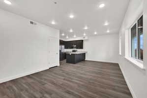 Open-concept living space featuring wood-finish flooring, recessed lighting, and white trim