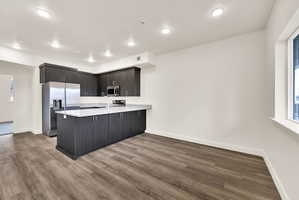 Modern kitchen featuring dark wood-finish cabinetry and an island with a white speckled countertop