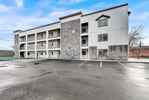 Modern multi-story building featuring a facade of horizontal siding and stacked stone veneer
