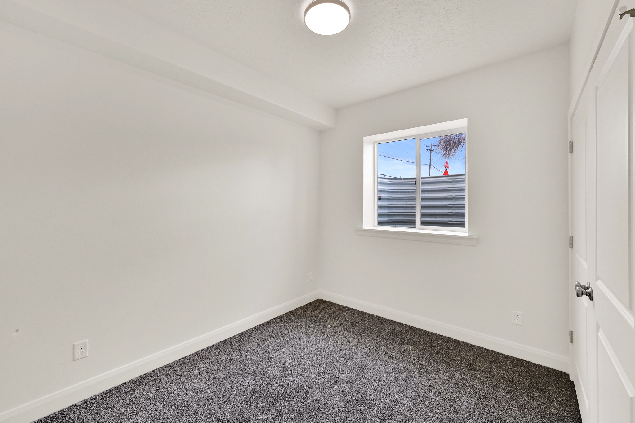 Room featuring neutral wall paint, gray carpet flooring, a single window, and a flush mount ceiling light