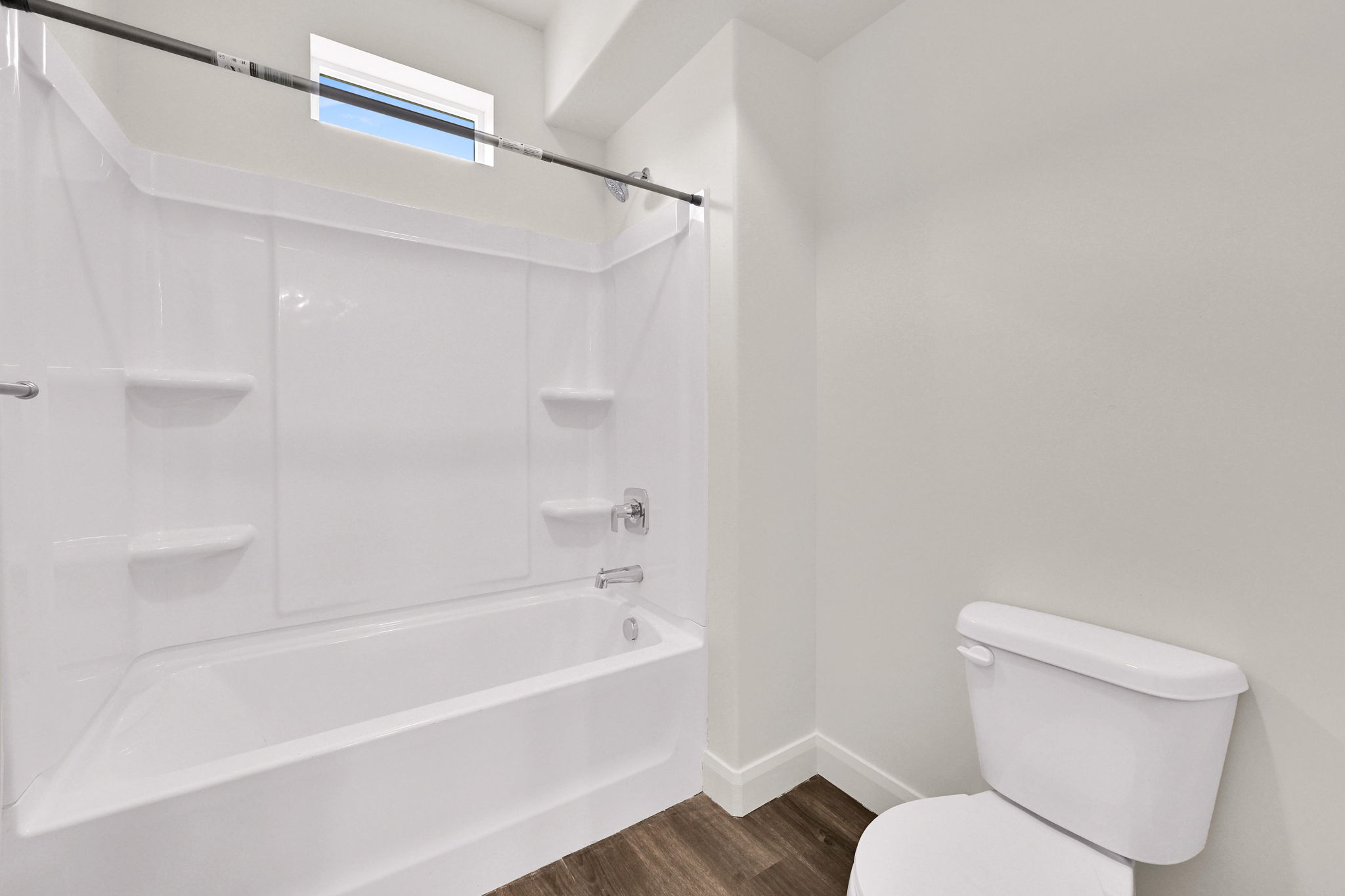 Bathroom featuring a white tub with integrated shelving, chrome fixtures, and a shower curtain rod