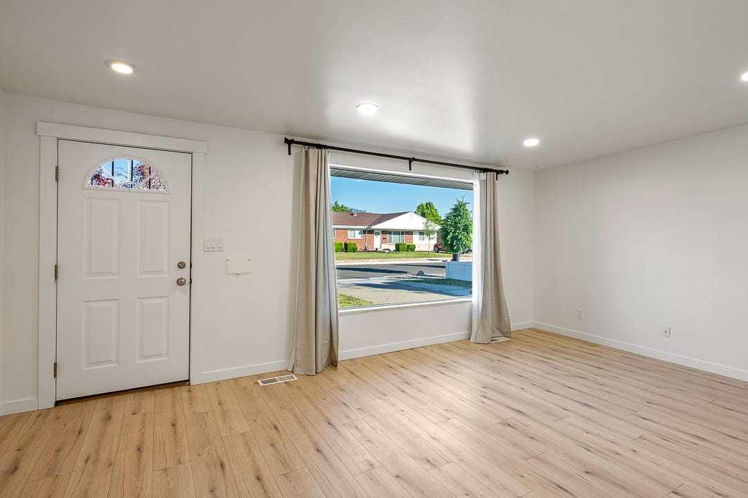 Spacious room featuring wood-finish flooring, recessed lighting, and a large picture window