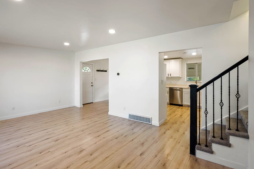 Spacious living area featuring wood-finish flooring, recessed lighting, and a neutral color palette
