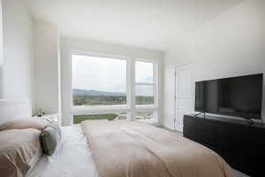 Expansive window wall with white framing, providing abundant natural light and scenic distant mountain and city views