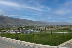 Community park with green spaces, paved pathways, and mountain scenery