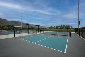 Outdoor pickleball courts featuring a durable playing surface, perimeter fencing, and mountain scenery