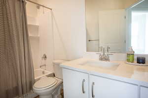 Bathroom featuring a white vanity with a light-colored speckled countertop, an undermount sink, and brushed nickel hardware